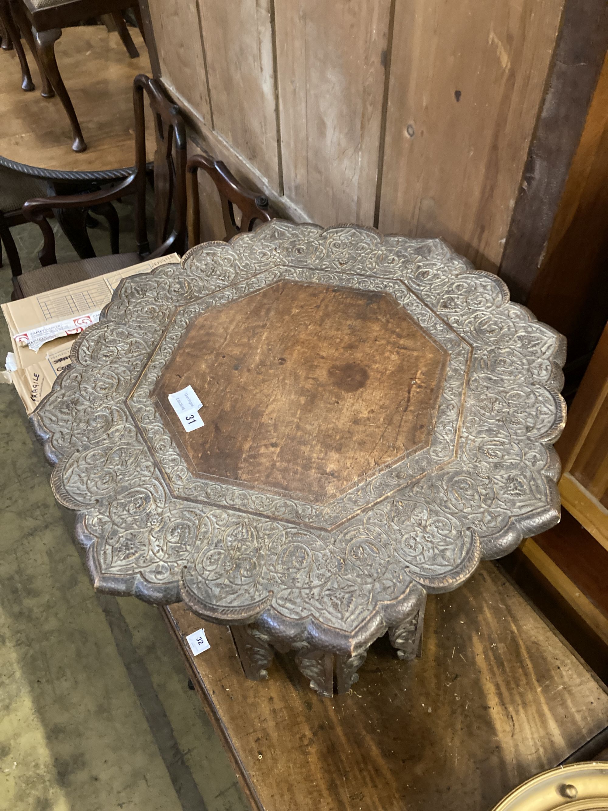 An Indian carved hardwood coffee table on a folding stand, width 63cm height 60cm